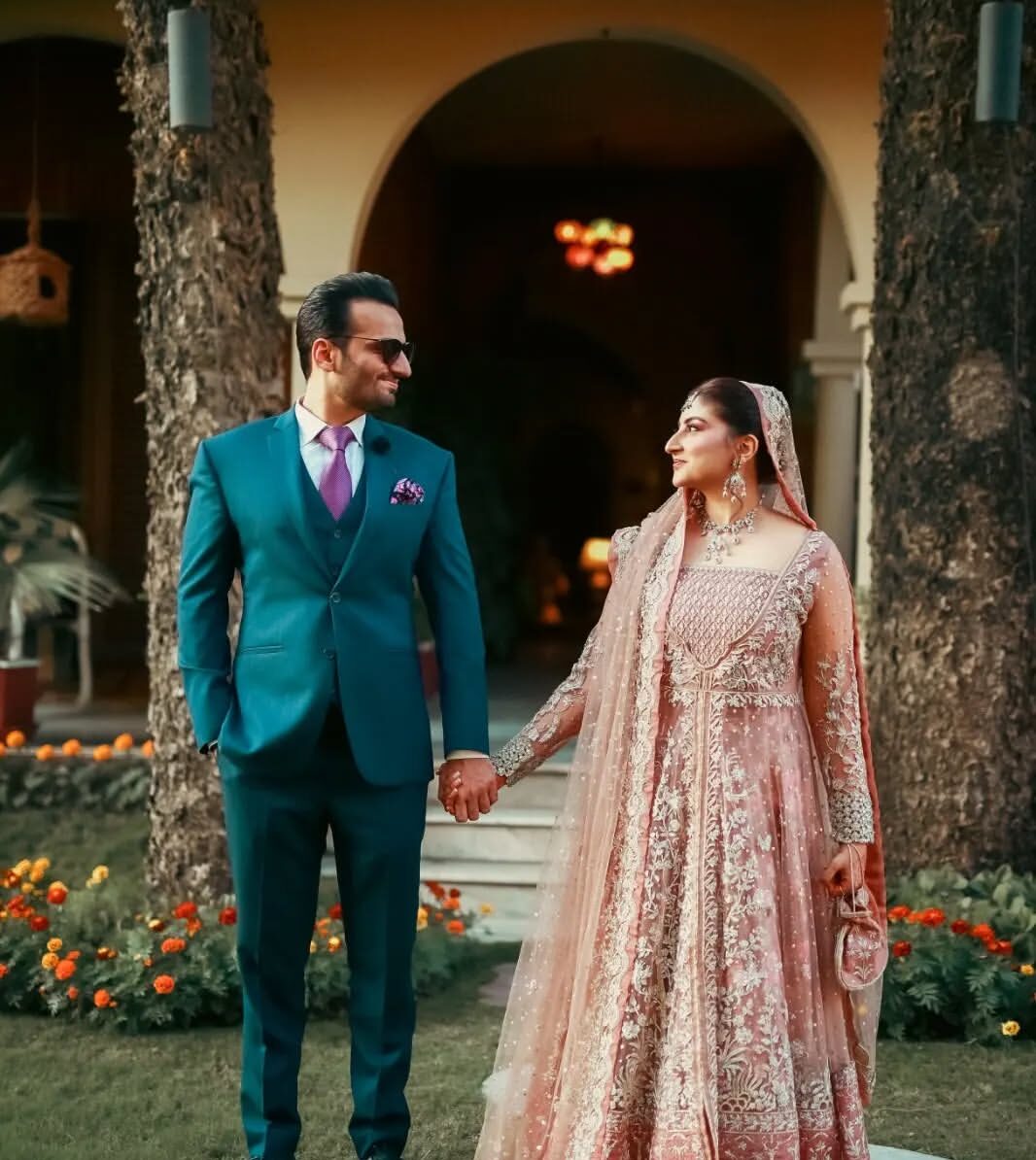 Close-up pre-wedding photo of couple surrounded by green plants