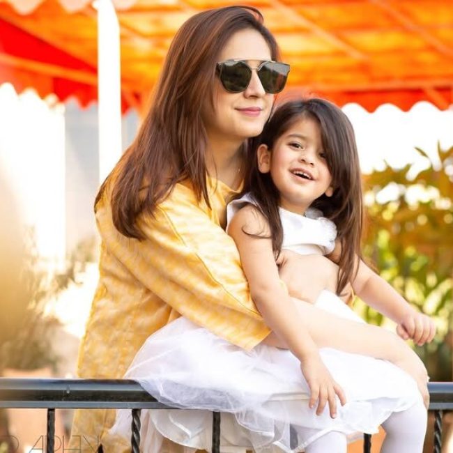 Mother and daughter sitting on bench