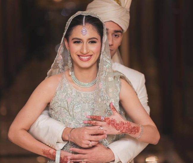Couple sitting on stage sofa during pre-wedding shoot in hall