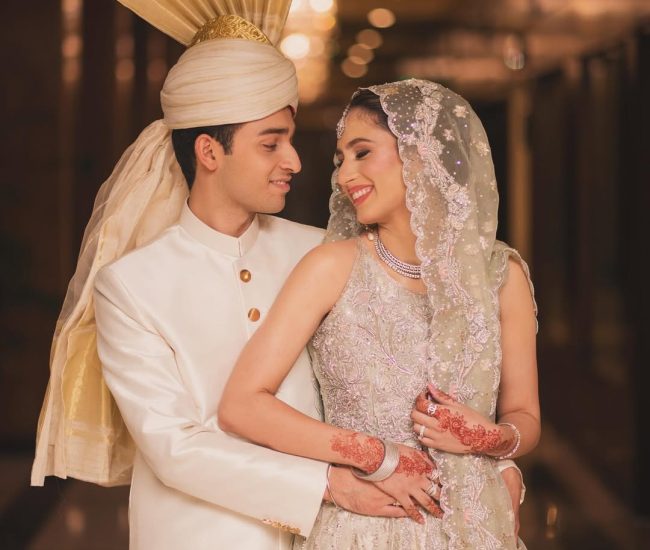 Bride and groom in traditional attire on marriage hall stage