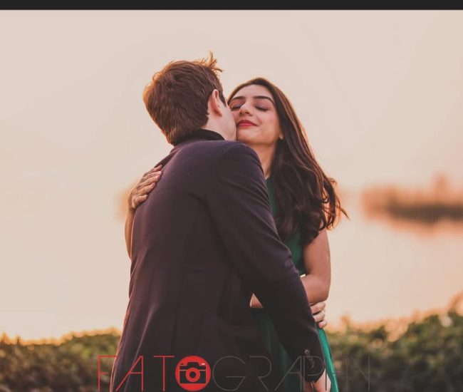The bride and groom sharing a tender hug from the side, with the groom's face obscured, during an intimate outdoor couple's shoot.