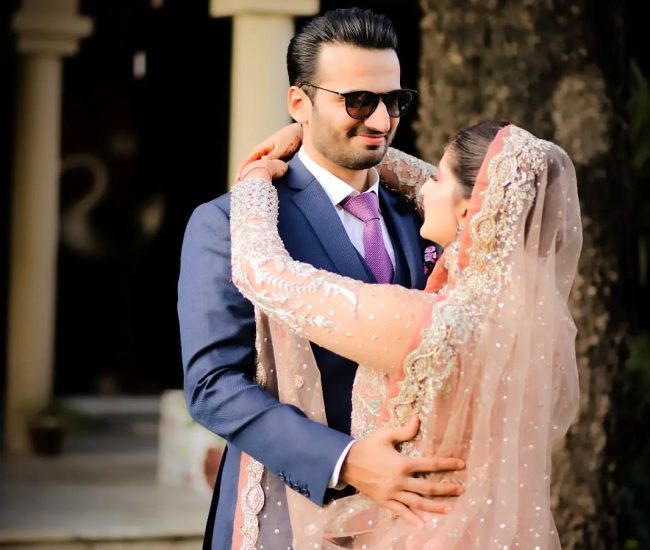 Couple sitting under tree during pre-wedding shoot in home garden