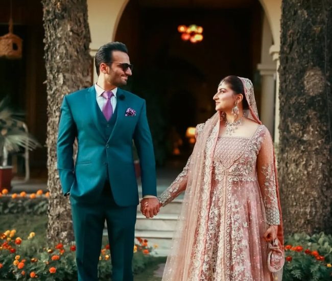 Close-up pre-wedding photo of couple surrounded by green plants