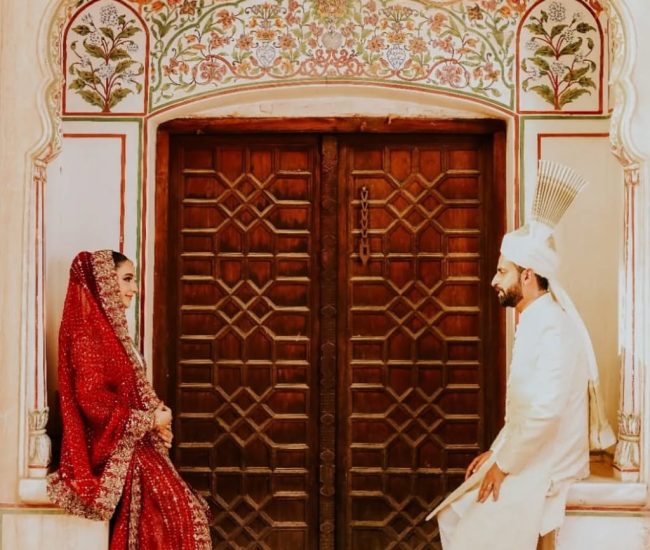 Playful couple lifting pose for pre-wedding photography in village