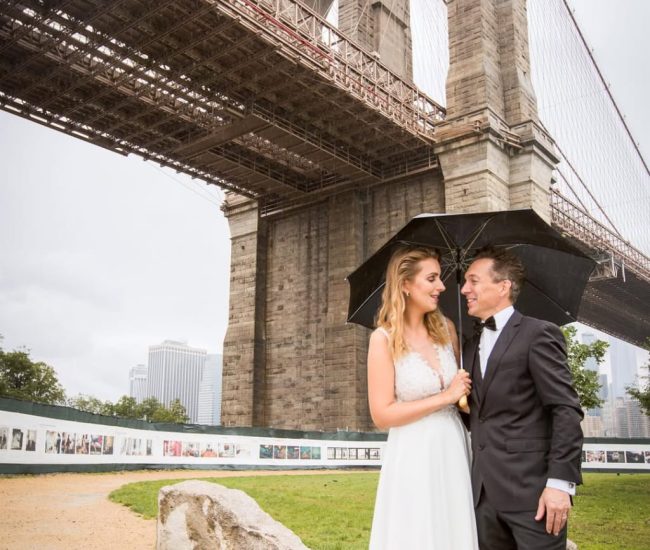 Silhouette of groom standing on a bridge with city skyline in background during Fatography pre wedding photography.