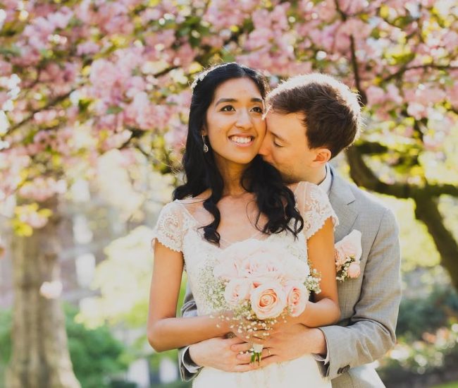 Groom leaning stylishly against a street wall during Fatography pre wedding shoot.