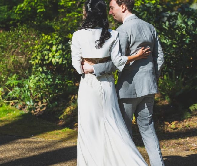 Groom in formal attire standing under tree shade in a Fatography pre wedding garden shoot.