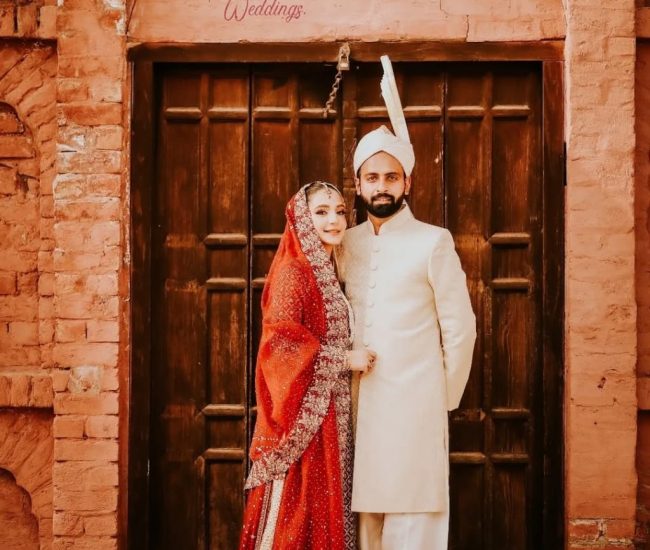 Couple walking hand in hand through green village fields