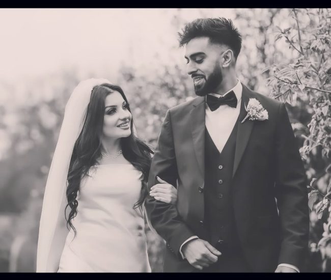 Couple walking together during romantic pre-wedding garden shoot