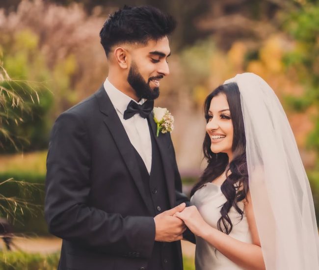 Close-up of bride and groom’s hands with bouquet in pre-wedding shoot