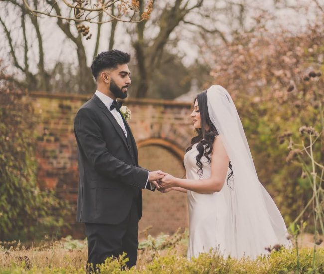 Couple walking together in green garden during pre-wedding shoot