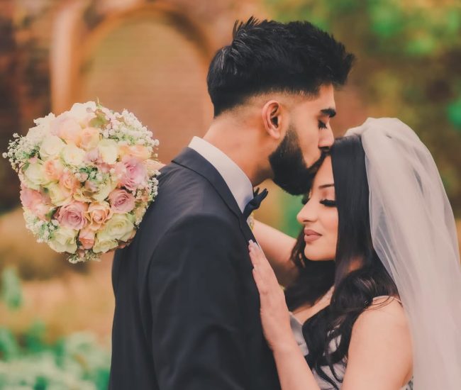 Groom kissing bride’s forehead during pre-wedding shoot