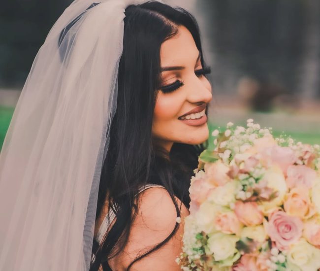 Bride posing with bouquet and veil in garden pre-wedding shoot