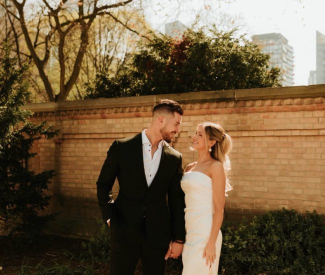 Bride and groom laughing together near a city building during Fatography pre wedding photography.
