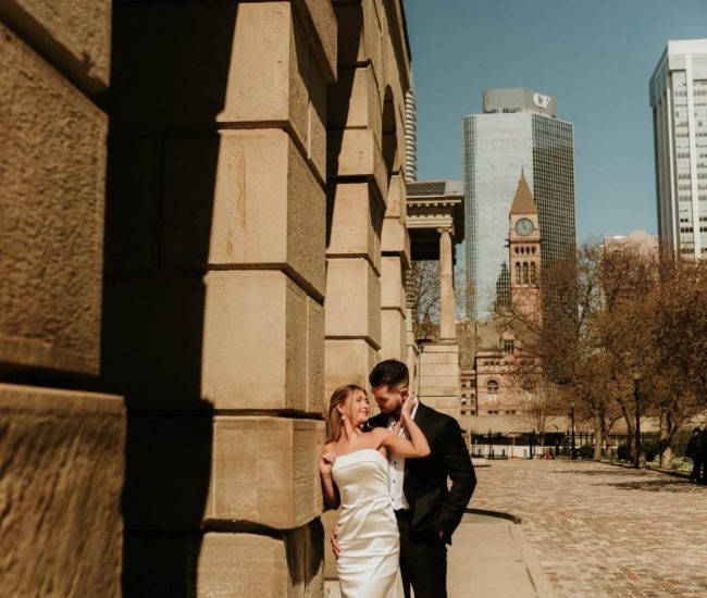 Bride looking at groom lovingly near an urban glass building during Fatography pre wedding shoot
