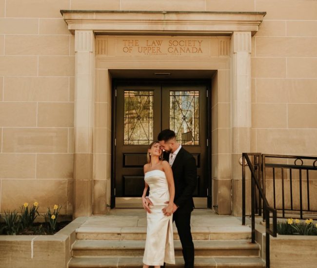 Groom lifting bride near a city building in a Fatography pre wedding shoot.