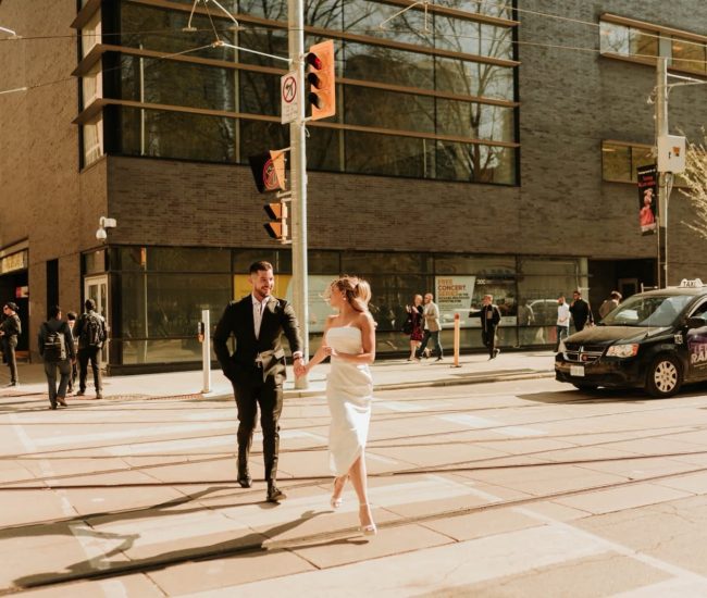 Couple holding hands while crossing the street in a Fatography pre wedding photoshoot.
