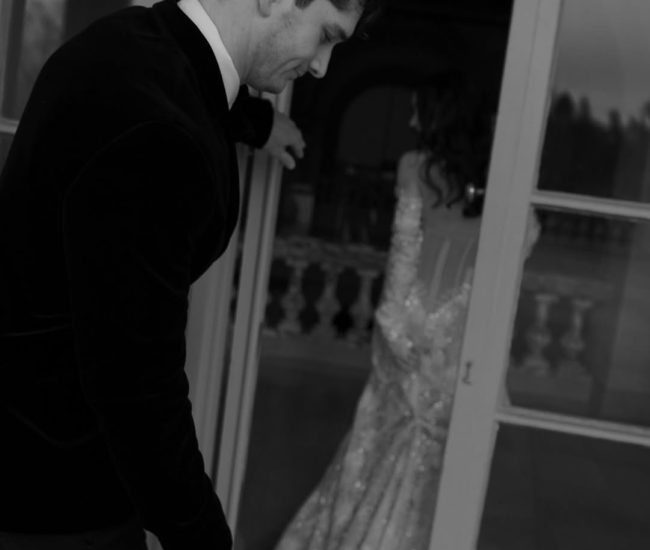 Romantic indoor moment with bride in white suit and groom in black during a Fatography pre wedding shoot.