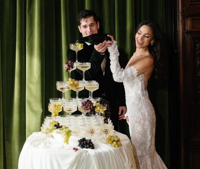 Bride in white suit and groom in black captured in a Fatography pre wedding indoor photoshoot.