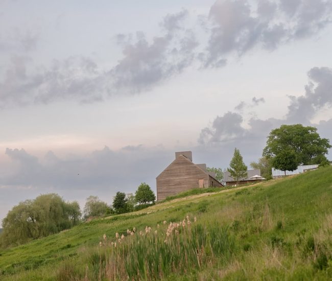 Couple standing together in an open green field during a Fatography pre wedding shoot.