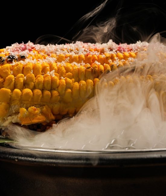 Grilled corn topped with seasoning – vibrant food photography in Dubai