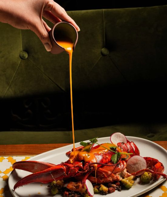 Pouring sauce over meat – creative food photography in Dubai