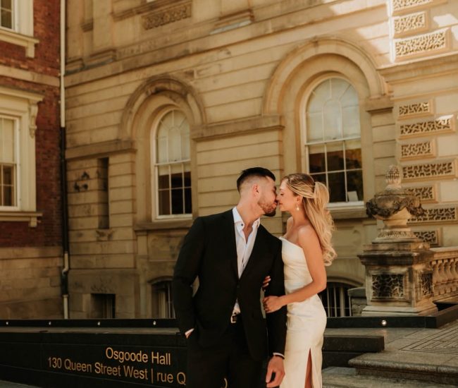 Bride and groom posing with tall city buildings in a Fatography pre wedding shoot.